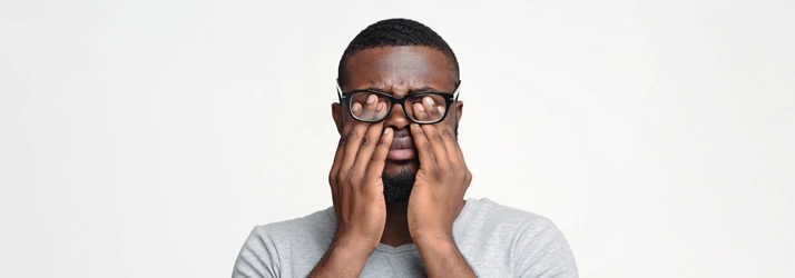 Eye Doctor Cape Girardeau MO Eye Conditions A man rubbing his eyes under his glasses.