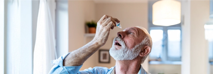 Eye Doctor Cape Girardeau MO Eye Drops A man with a grey beard using eye drops.