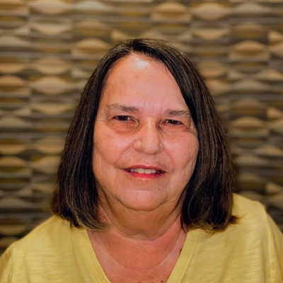 Marsha Lappe smiling in a yellow shirt.