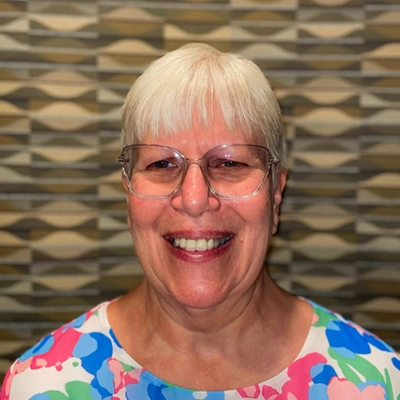 Penny Lite smiling in a colorful shirt.