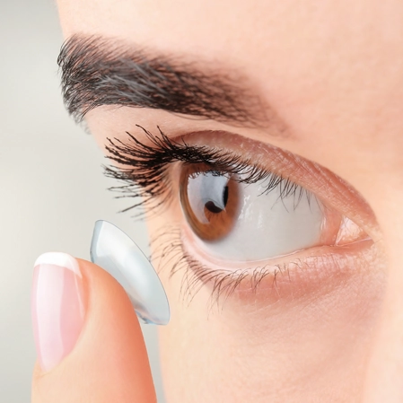 A person putting a contact in their eye.